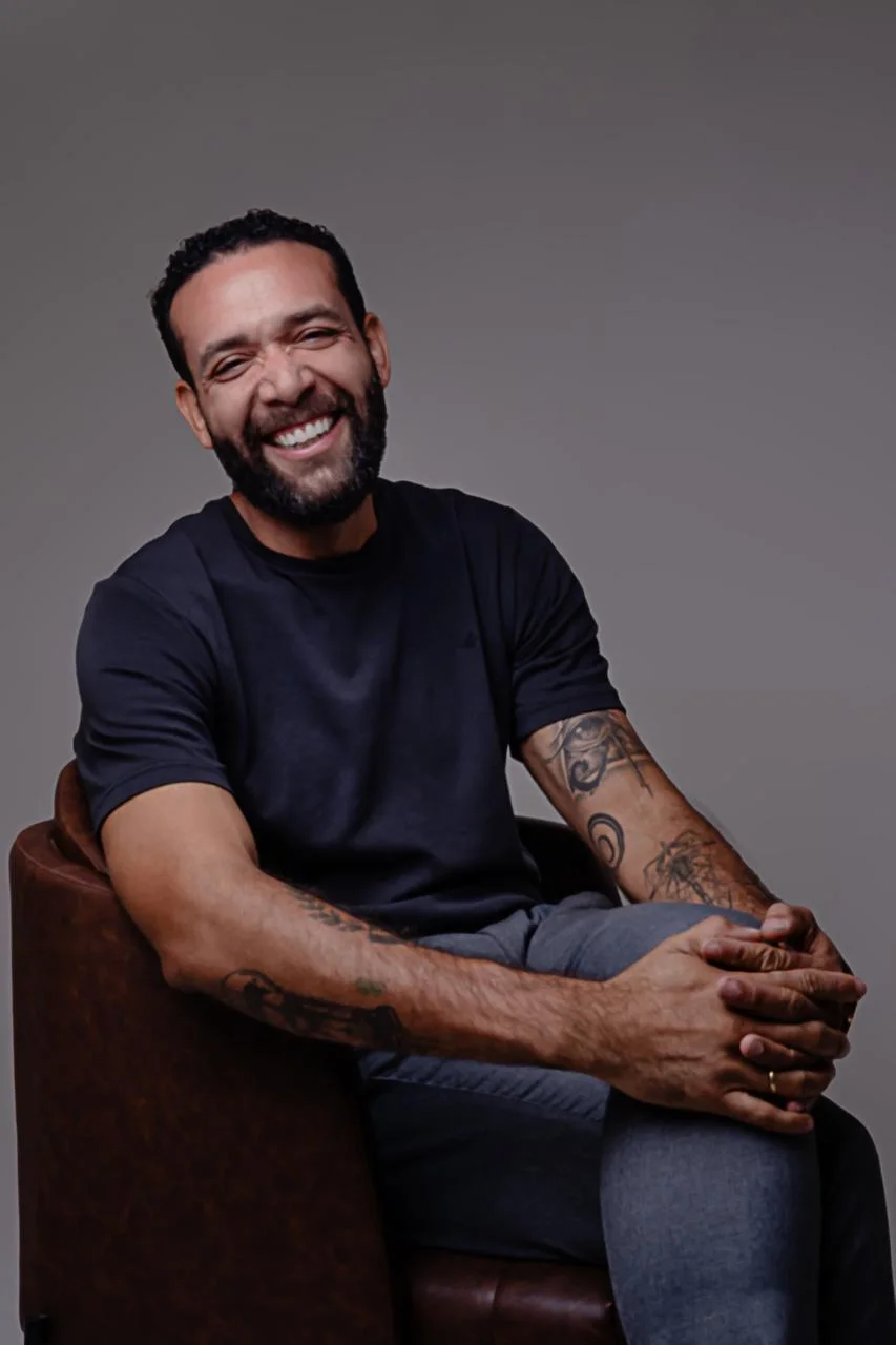 Marcelo Schmitsler sorrindo, sentado em uma poltrona