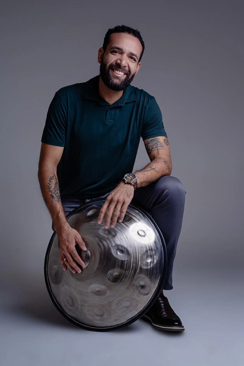 Marcelo Schmitsler sentado com seu handpan, sorrindo
